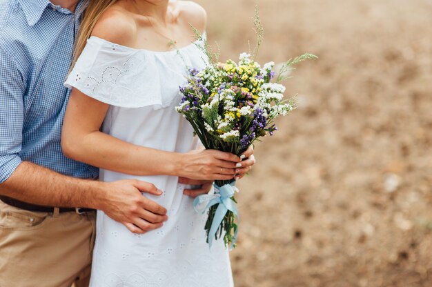 Bruid die mooi boeket van wilde bloemen houdt