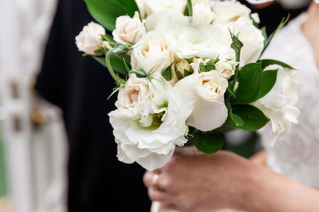 Bruid die witte bloemen houdt als huwelijksboeket op speciale dag