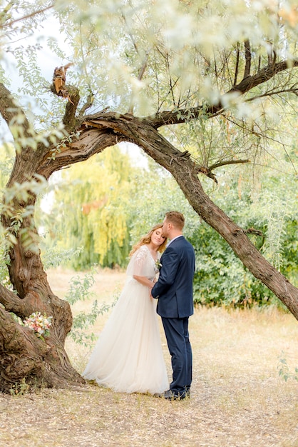Bruid en bruidegom die onder de boom blijven