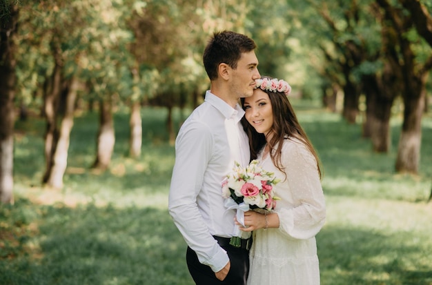 Bruid en bruidegom in een bos met een bloemkroon