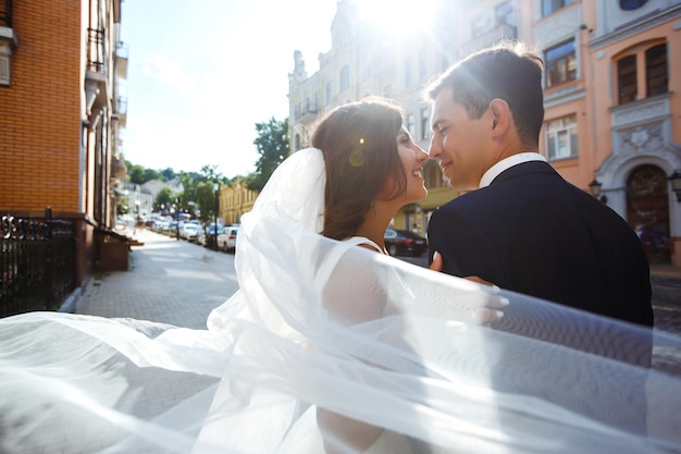 Bruid en bruidegom kussen teder in de schaduw van een vliegende sluier Together Wedding Love