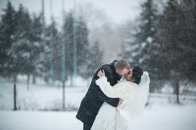 Foto bruid en bruidegom lopen op de europese stad in de sneeuw