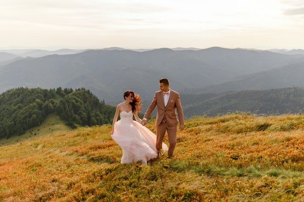 Bruid en bruidegom poseren in de bergen