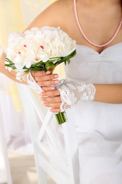 Bruid houden bruiloft boeket van witte pioenrozen close-up op lichte achtergrond