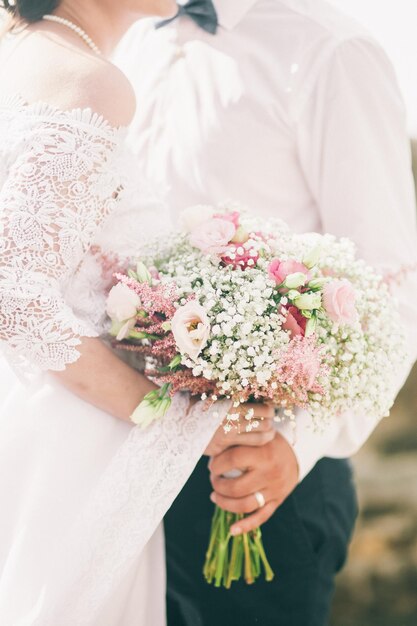 Bruid houdt bruiloft boeket van rozen pioenrozen en rozen Handen close-up