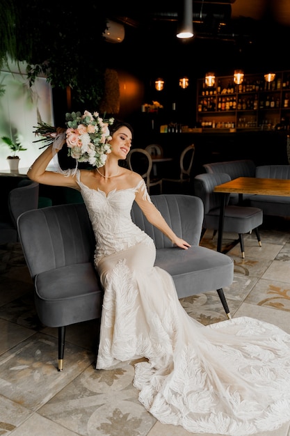Bruid in bruiloft dressseats op mode stoel in café.