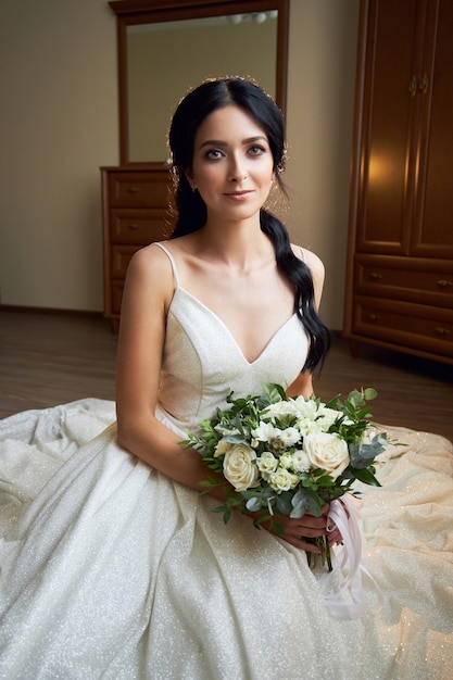 Bruid in een mooie witte jurk met een boeket bloemen