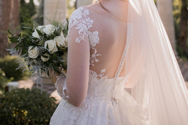 Bruid in een trouwjurk houdt een boeket vast