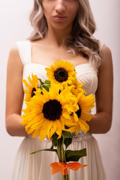 Bruid in een trouwjurk met een boeket zonnebloemen mooie vrouwFloristiek