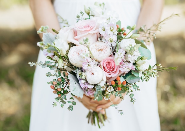 Bruid met bruidsboeket met witte en roze bloemen