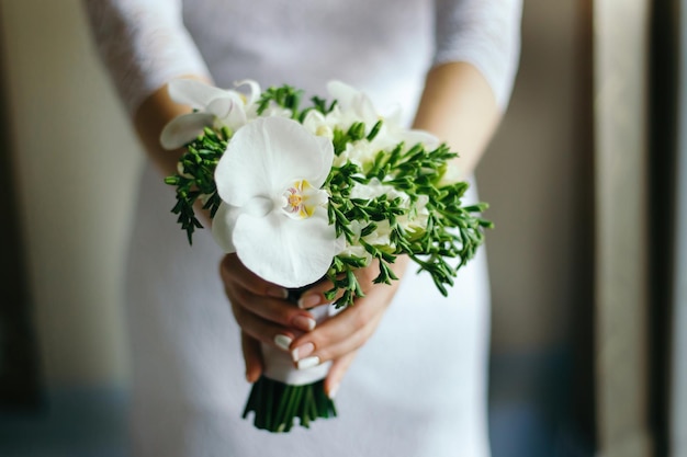 Bruid met een boeket witte Orchidee in de handen