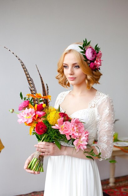 Bruid met helder boeket en bloemen in haar haar