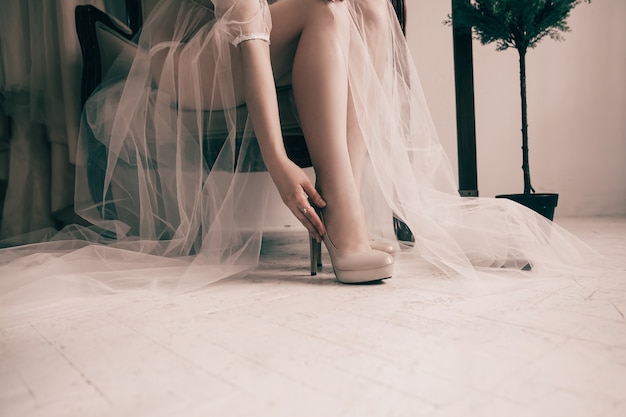 Bruid probeert op elegante trouwschoenen.