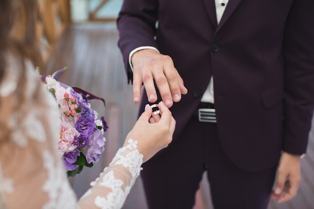 Bruid zet ring op de vinger van bruidegom.