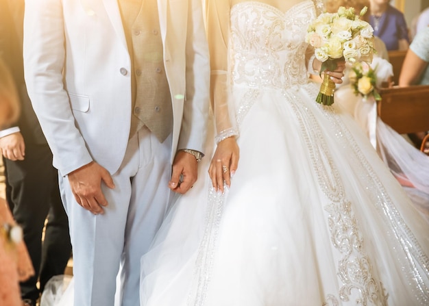 Bruidegom in blauw pak en bruid in luxe jurk zijn in de kerk Huwelijksceremonie Verliefde paar
