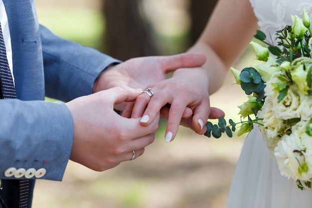 Bruidegom plaatst de ring om de vinger van de bruid