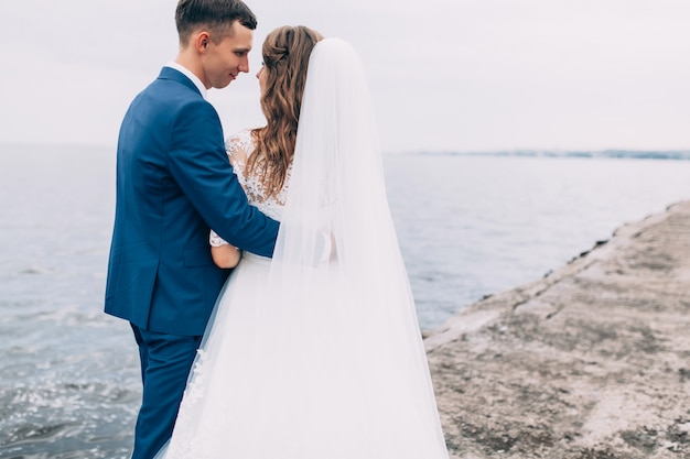 Bruidspaar op de zee, liefhebbers op de pier