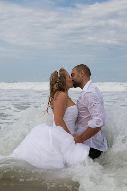 Bruidspaar op het strand met trouwkleding