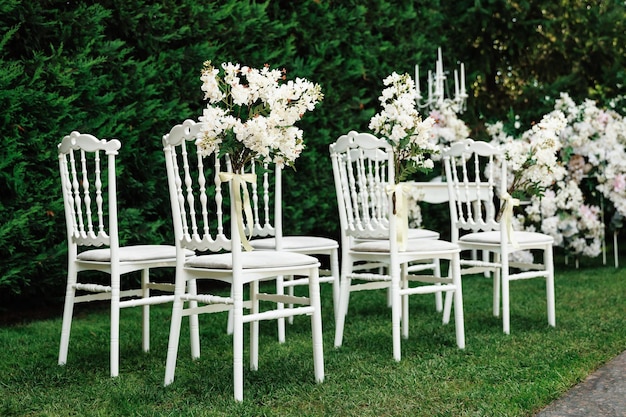 Foto bruidsstoel versierd met witte bloemen in de natuur