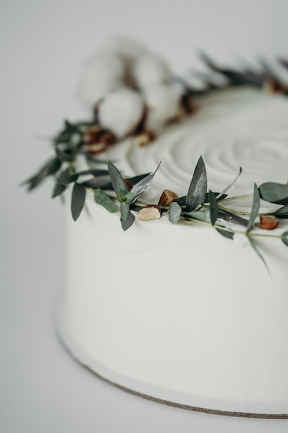 Foto bruidstaart in wit met eucalyptus bloemen en katoen