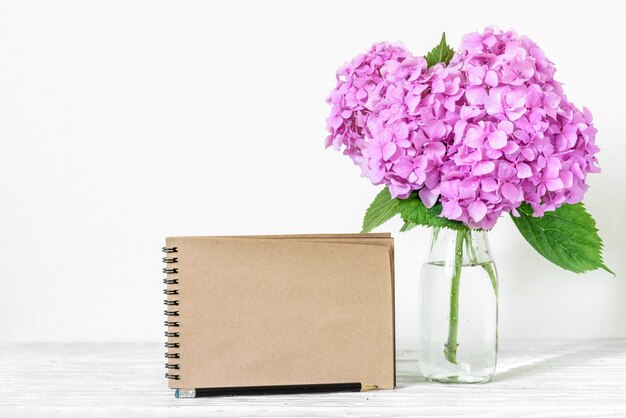 Bruiloft ambachtelijke papieren kaart met boeket van roze hortensia bloemen in vaas.