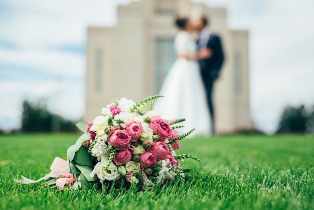 Bruiloft boeket met gouden ringen op het gras