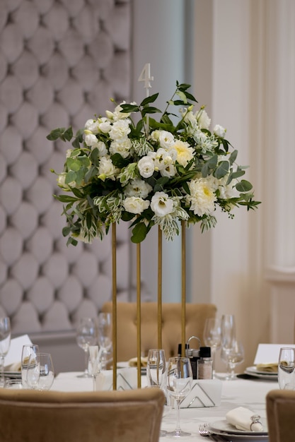 Bruiloft centerpieces, met metalen vaas en witte verse bloemen arrangementen.