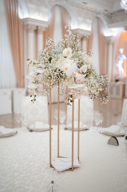 Bruiloft centerpieces, met metalen vaas en witte verse bloemen arrangementen.