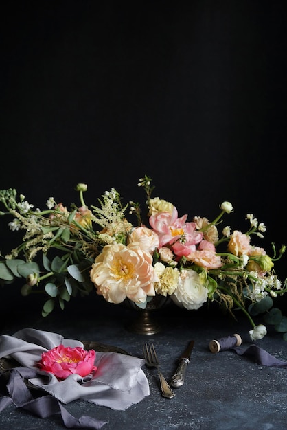 Bruiloft decor, roze pioen op zijden servetten en bloemstuk op een donkere achtergrond, bruiloft boeket, decorateur, kopie ruimte, selectieve aandacht