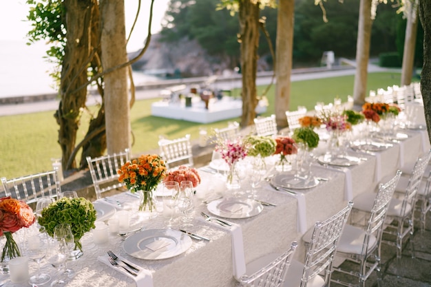 Bruiloft eettafel receptie een zeer lange tafel voor gasten met een wit tafelkleed bloemen