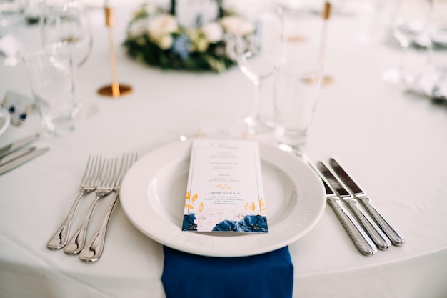 Bruiloft eettafel receptie wit bord op tafel drie vorken aan de linkerkant drie messen aan de