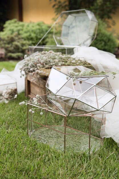 Foto bruiloft glazen dozen voor enveloppen voor groeten op houten tafeltje en het witte weefsel met planten als decoratie