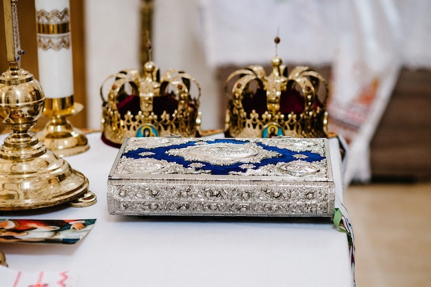 Bruiloft kronen en bijbel. Huwelijkskroon in kerk klaar voor huwelijksceremonie. detailopname. Goddelijke Liturgie.