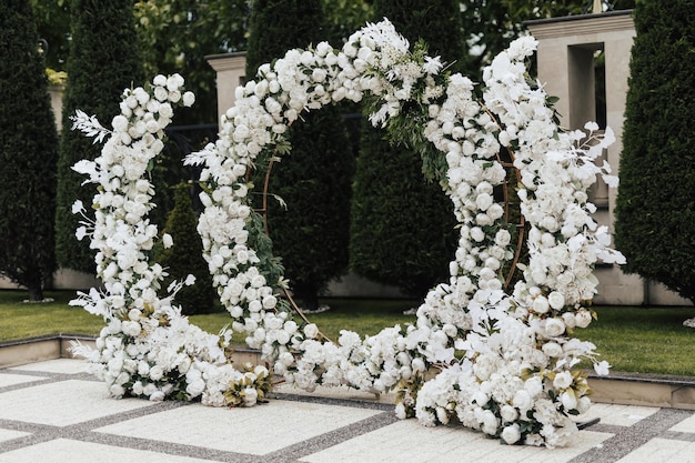 bruiloft ronde boog versierd met witte bloemen en groen