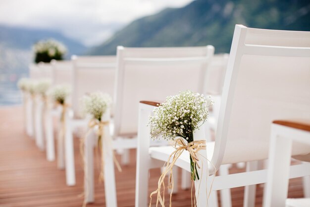 Bruiloft stoelen met bloemen decoratie. Trouwlocatie ceremonie.