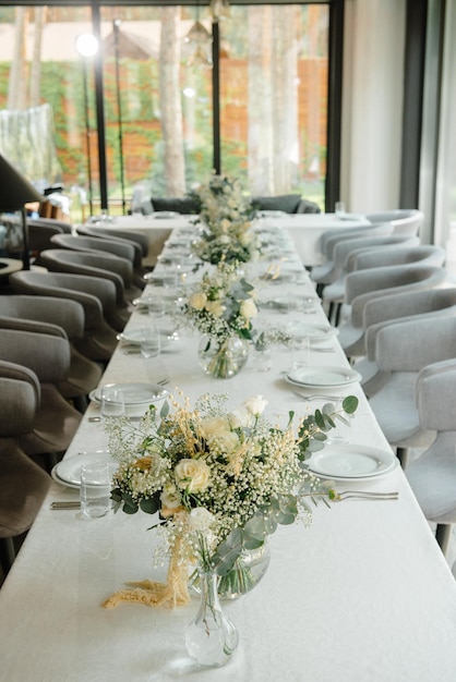 Bruiloftsreceptietafel in het restaurant versierd met witte kaarsen en bloemen