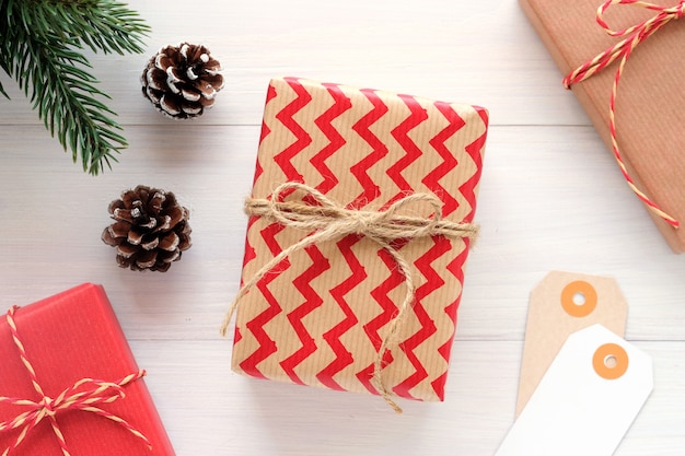 Bruin en rood uitstekend giftvakje en ornament op witte houten achtergrond, Kerstmisgroet c