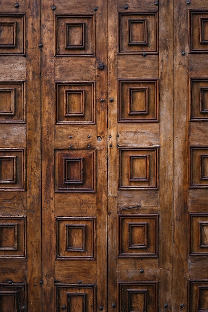 Bruin houten deur van een kerk in Italië met gebeeldhouwde decoraties