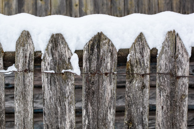 Bruin houten landelijke hek vallende sneeuw