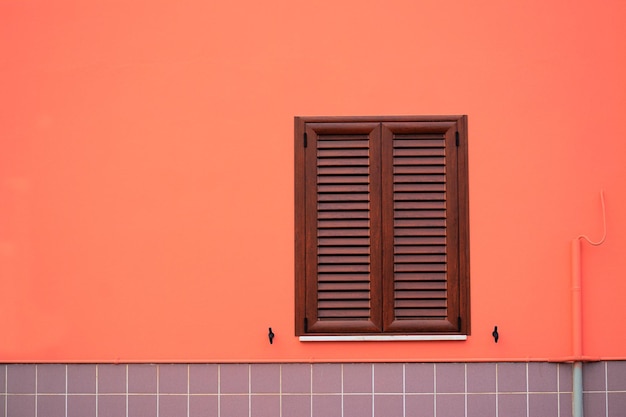 Bruin raam in een oranje en grijze muur