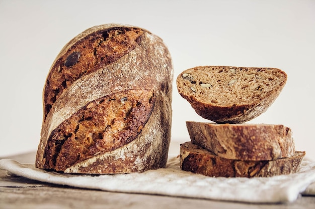 Bruin vers brood met zaden wordt in stukjes gesneden op een oude houten ondergrond. Kopiëren, lege ruimte voor tekst