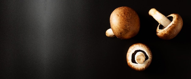 Bruine champignons op een zwarte achtergrond met kopie ruimte.
