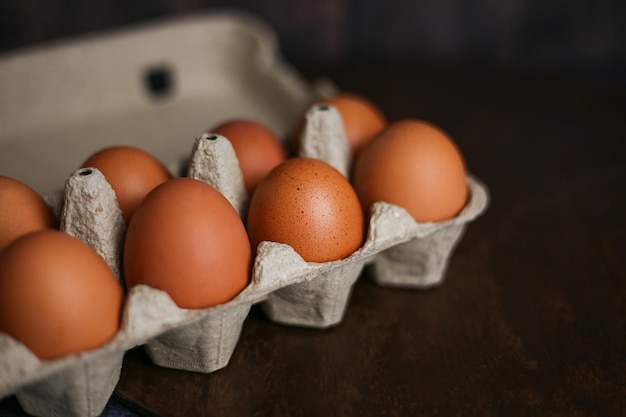 Bruine eieren in ecoverpakking van gerecyclede materialen op een donkere houten ondergrond