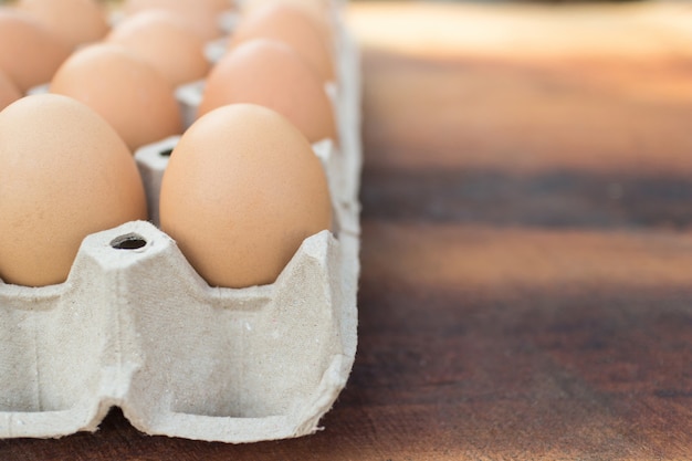 Bruine eieren in pakket op een houten lijst