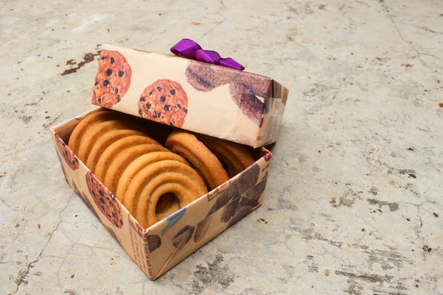Bruine geschenkdoos met cookies binnen op oude cementvloer