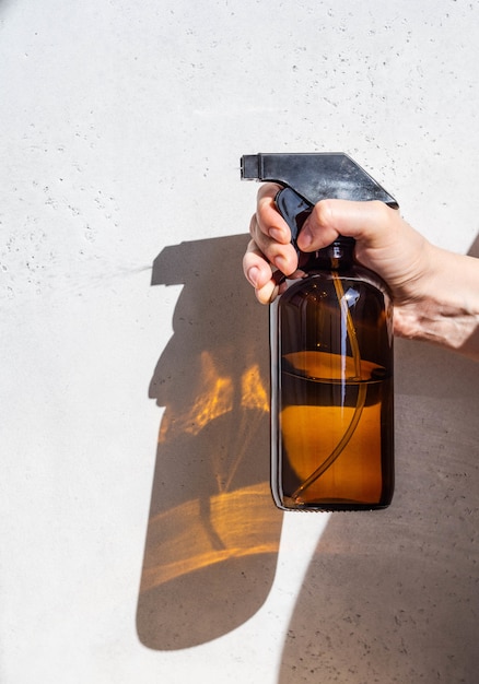 Bruine glazen spray fles in een vrouwelijke hand