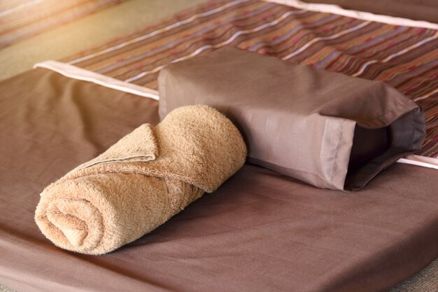 Bruine handdoek en kussen op beddecoratie in slaapkamerinterieur