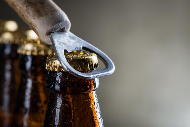 Foto bruine ijskoude bierflesjes met oude opener