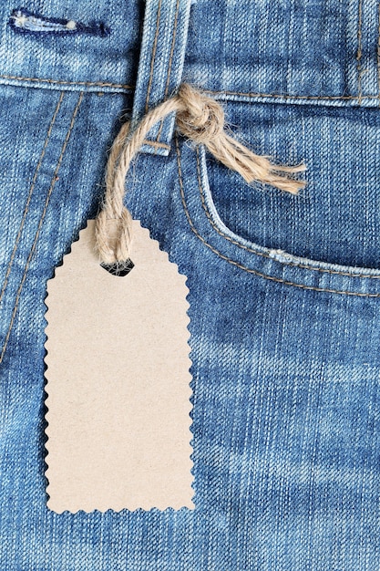 Bruine papieren label met henneptouw gebonden op denim of jeans.