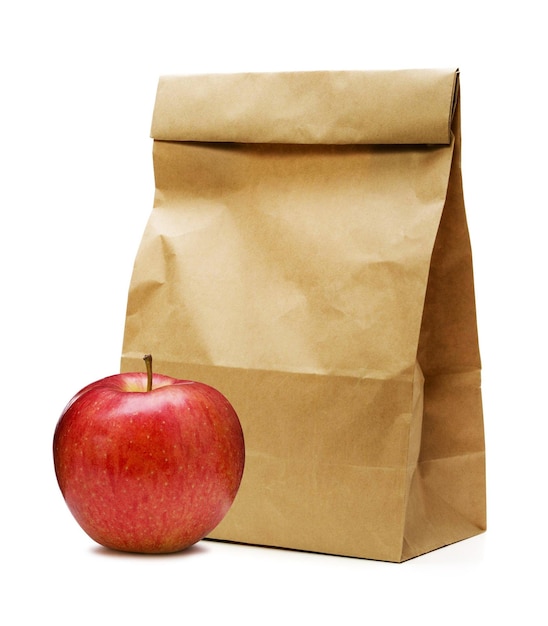 Bruine papieren zak en appel op wit